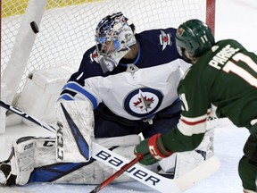 Minnesota Wild left winger Zach Parise (11) scores his second goal against Winnipeg Jets goaltender Eric Comrie (1) during the first period in St. Paul, Minn. (AP Photo/Hannah Foslien)