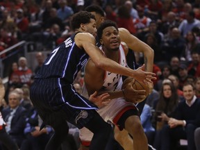 Kyle Lowry of the Raptors tries to bust through two Magic defenders in Game 2. JACK BOLAND/TORONTO SUN