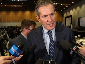 Premier Brian Pallister speaks to reporters following a speech to the Manitoba Chambers of Commerce on Thursday.