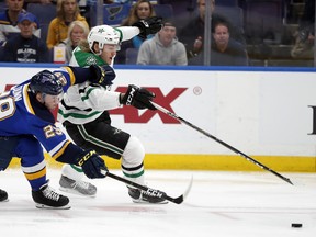 Blues’ Vince Dunn (left) and Stars’ Roope Hintz chase a loose puck during Game 1 in St. Louis. (AP PHOTO)