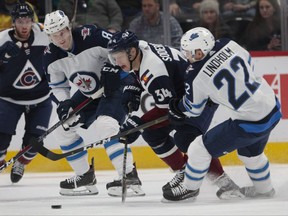 Colorado Avalanche center Carl Soderberg skates between Winnipeg Jets defenceman Jacob Trouba and centre Par Lindholm in Denver last night. (AP)