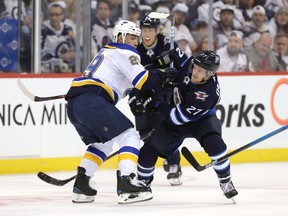 Vince Dunn of the St. Louis Blues battles Nikolaj Ehlers of the Winnipeg Jets (27) in Game 5 of the Western Conference First Round during the 2019 NHL Stanley Cup Playoffs at Bell MTS Place on Friday.