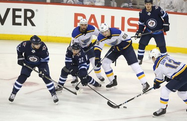 WINNIPEG, MANITOBA - APRIL 10: Adam Lowry #17 and Par Lindholm #22 of the Winnipeg Jets fight for a loose puck with Robert Bortuzzo #41, Colton Parayko #55 and Zach Sanford #12 of the St. Louis Blues  in Game One of the Western Conference First Round during the 2019 NHL Stanley Cup Playoffs at Bell MTS Place on April 10, 2019 in Winnipeg, Manitoba, Canada. (Photo by Jason Halstead/Getty Images)