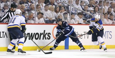 WINNIPEG, MANITOBA - APRIL 10: Mark Scheifele #55 of the Winnipeg Jets tries to move the puck past Ryan O'Reilly #90 and Vladimir Tarasenko #91 of the St. Louis Blues in Game One of the Western Conference First Round during the 2019 NHL Stanley Cup Playoffs at Bell MTS Place on April 10, 2019 in Winnipeg, Manitoba, Canada. (Photo by Jason Halstead/Getty Images)