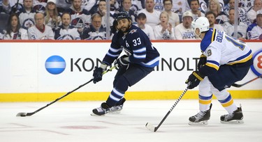 WINNIPEG, MANITOBA - APRIL 10: Dustin Byfuglien #33 of the Winnipeg Jets looks to shoot under pressure from Jay Bouwmeester #19 of the St. Louis Blues in Game One of the Western Conference First Round during the 2019 NHL Stanley Cup Playoffs at Bell MTS Place on April 10, 2019 in Winnipeg, Manitoba, Canada. (Photo by Jason Halstead/Getty Images)