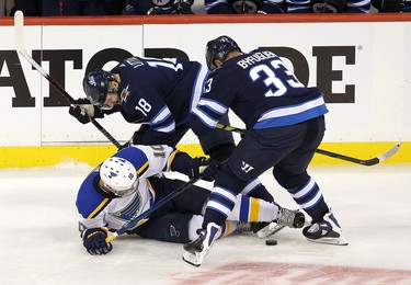 WINNIPEG, MANITOBA - APRIL 10: Brayden Schenn #10 of the St. Louis Blues battles with Bryan Little #18 and Dustin Byfuglien #33 of the Winnipeg Jets in Game One of the Western Conference First Round during the 2019 NHL Stanley Cup Playoffs at Bell MTS Place on April 10, 2019 in Winnipeg, Manitoba, Canada. (Photo by Jason Halstead/Getty Images)