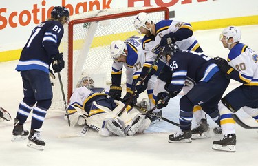 WINNIPEG, MANITOBA - APRIL 10: Jordan Binnington #50 of the St. Louis Blues makes a save as Mark Scheifele #55 and Kyle Connor #81 of the Winnipeg Jets try to jam the puck in during Game One of the Western Conference First Round during the 2019 NHL Stanley Cup Playoffs at Bell MTS Place on April 10, 2019 in Winnipeg, Manitoba, Canada. (Photo by Jason Halstead/Getty Images)