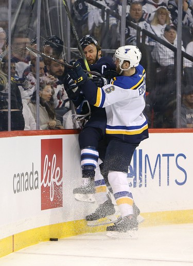 WINNIPEG, MANITOBA - APRIL 10: Joel Edmundson #16 of the St. Louis Blues hits Blake Wheeler #26 of the Winnipeg Jets in Game One of the Western Conference First Round during the 2019 NHL Stanley Cup Playoffs at Bell MTS Place on April 10, 2019 in Winnipeg, Manitoba, Canada. (Photo by Jason Halstead/Getty Images)