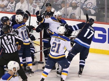 WINNIPEG, MANITOBA - APRIL 10: Adam Lowry #17 of the Winnipeg Jets grabs Pat Maroon #7 of the St. Louis Blues in Game One of the Western Conference First Round during the 2019 NHL Stanley Cup Playoffs at Bell MTS Place on April 10, 2019 in Winnipeg, Manitoba, Canada. (Photo by Jason Halstead/Getty Images)
