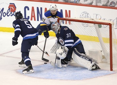 WINNIPEG, MANITOBA - APRIL 10: Tyler Bozak #21 of the St. Louis Blues tries a wrap-around on Connor Hellebuyck #37 of the Winnipeg Jets in Game One of the Western Conference First Round during the 2019 NHL Stanley Cup Playoffs at Bell MTS Place on April 10, 2019 in Winnipeg, Manitoba, Canada. (Photo by Jason Halstead/Getty Images)