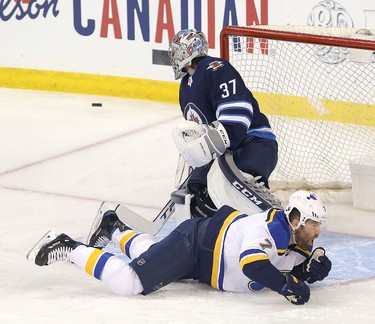 WINNIPEG, MANITOBA - APRIL 10: Pat Maroon #7 of the St. Louis Blues hits the ice in front of the Winnipeg Jets Connor Hellebuyck #37 in Game One of the Western Conference First Round during the 2019 NHL Stanley Cup Playoffs at Bell MTS Place on April 10, 2019 in Winnipeg, Manitoba, Canada. (Photo by Jason Halstead/Getty Images)
