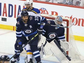 WINNIPEG, MANITOBA - APRIL 12: Pat Maroon #7 of the St. Louis Blues fights for space with Dustin Byfuglien #33 and Connor Hellebuyck #37 of the Winnipeg Jets in Game Two of the Western Conference First Round during the 2019 NHL Stanley Cup Playoffs at Bell MTS Place on April 12, 2019 in Winnipeg, Manitoba, Canada.