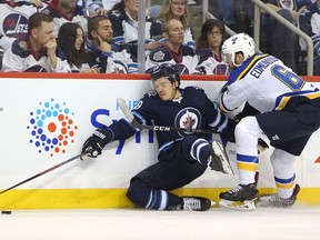 WINNIPEG, MANITOBA - APRIL 12: Jack Roslovic #28 of the Winnipeg Jets battles for the puck with Joel Edmundson #16 of the St. Louis Blues in Game Two of the Western Conference First Round during the 2019 NHL Stanley Cup Playoffs at Bell MTS Place on April 12, 2019 in Winnipeg, Manitoba, Canada.