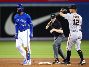 Toronto Blue Jays Teoscar Hernandez, left, is called out at second base on a throw by Gerardo Parra (not pictured) to Joe Panik, right, of the San Francisco Giants during their game at the Rogers Centre on April 24, 2019 in Toronto. (Vaughn Ridley/Getty Images)