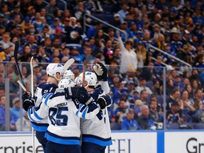 Members of the Winnipeg Jets including Mathieu Perreault (85) celebrate after scoring a goal against the St. Louis Blues in Game Three of the Western Conference First Round during the 2019 NHL Stanley Cup Playoffs on Sunday in St. Louis.