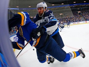 Blake Wheeler of the Winnipeg Jets checks Oskar Sundqvist of the St. Louis Blues into the boards in Game 3 of the Western Conference First Round during the 2019 NHL Stanley Cup Playoffs on Sunday in St. Louis.