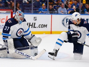 ST. LOUIS, MO - APRIL 14: Connor Hellebuyck #37 of the Winnipeg Jets makes a save as Ben Chiarot #7 of the Winnipeg Jets attempts to deflect the puck against the St. Louis Blues in Game Three of the Western Conference First Round during the 2019 NHL Stanley Cup Playoffs at the Enterprise Center on April 14, 2019 in St. Louis, Missouri.