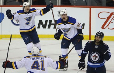 St. Louis Blues centre Tyler Bozak (right) celebrates his game-winning during Game 1 of Round 1 of the NHL playoffs against the Jets in Winnipeg with Robert Thomas (left) and Robert Bortuzzo (bottom) on Wed., April 10, 2019. Kevin King/Winnipeg Sun/Postmedia Network
