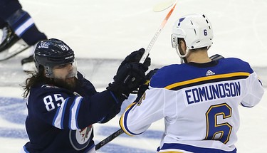 Winnipeg Jets forward Mathieu Perreault (left) and St. Louis Blues defenceman Joel Edmundson battle during Game 1 of Round 1 of the NHL playoffs in Winnipeg on Wed., April 10, 2019. Kevin King/Winnipeg Sun/Postmedia Network