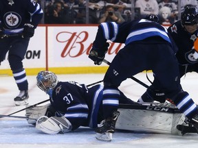 Winnipeg Jets goaltender Connor Hellebuyck is down and out, with the puck under him, during Game 5 of the first round of the NHL playoffs against the St. Louis Blues in Winnipeg on Thurs., April 18, 2019. Kevin King/Winnipeg Sun/Postmedia Network