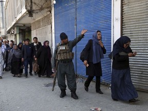 Staff of the Telecommunication Ministry are escorted after an attack outside the ministry building in Kabul, Afghanistan, Saturday, April 20, 2019.