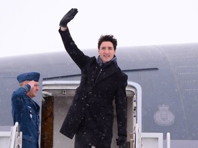 Canadian Prime Minister Justin Trudeau waves from the steps of his plane as he departs Ottawa for Davos, Switzerland for the annual World Economic Forum on Monday, January 22, 2018.