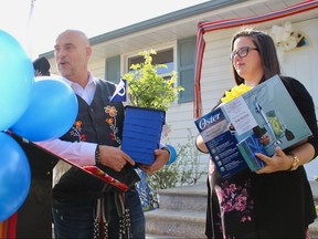 Manitoba Metis Federation Housing Minister Will Goodon presents first-time homeowner Dominic Bourgeois with gifts after she was formally handed the home she purchased with the assistance of the MMF's First-Time Buyers Program.
Scott Billeck/WInnipeg Sun/Postmedia Network