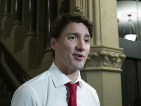 Prime Minister Justin Trudeau stops to talk to reporters as he makes his way to a meeting with his caucus in Ottawa on Wednesday, May 8, 2019.