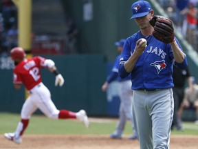 Blue Jays starter Clay Buchholz (right) reacts after giving up a two-run home run to Rougned Odor (left) of the Rangers during second inning MLB action at Globe Life Park in Arlington, Texas on Sunday, May 5, 2019.