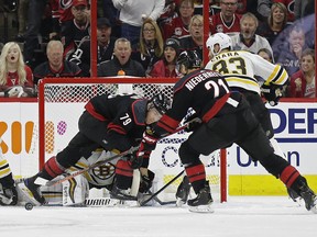 Carolina Hurricanes' Micheal Ferland and Nino Niederreiter try to score on Boston Bruins goalie Tuukka Rask during the first period in Game 3 of their Eastern Conference final series on Tuesday in Raleigh, N.C.