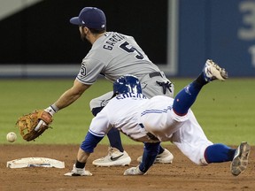 Toronto Blue Jays' Eric Sogard dives into second base with a double under the tag attempt by San Diego Padres second baseman Greg Garcia in Toronto Sunday May 26, 2019. (THE CANADIAN PRESS/Fred Thornhill)