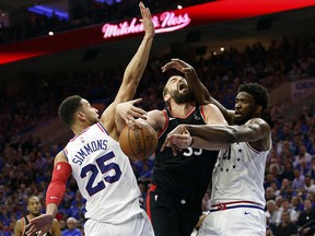 Toronto Raptors' Marc Gasol is fouled by Philadelphia 76ers' Ben Simmons, left, with Joel Embiid, right, also defending Thursday, May 2, 2019, in Philadelphia. (AP Photo/Chris Szagola)