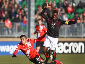 Cavalry FC’s Jose Escalante (left) is brought down by Valour FC’s Jordan Murrell during CPL soccer action in Calgary earlier this month. (JIM WELLS/POSTMEDIA NETWORK)