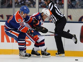 Winnipeg Jets forward Morris Lukowich (right) and Edmonton Oilers defenceman Craig Muni get their sticks into referee Andy Van Hellemond during the Heritage Classic alumni game in Winnipeg on Sat., Oct. 22, 2016. Kevin King/Winnipeg Sun/Postmedia Network file