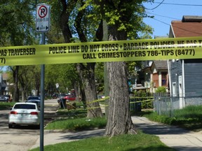 Police tape marks off an inner and outer perimeter in the 300 block of Alfred Avenue in Winnipeg on Monday. Emergency services responded to a call of several people fighting on Sunday evening. A male victim was found and transported to hospital in critical condition but later died from his injuries.