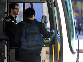 A transit rider prepares to pay his fare at a stop on Portage Avenue in Winnipeg on Mon., May 13, 2019. The Amalgamated Transit Union 1505, without a contract since January, is undertaking job action on Tuesday where its drivers will not enforce fare payment.