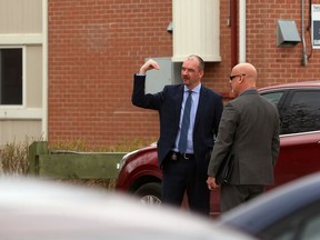 Homicide unit investigators in discussion near an apartment block in the 1000 block of Taylor Avenue on Sunday.