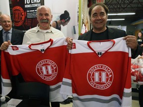 Brothers Dave (left) and Wayne Babych, two of the NHL alumnus taking part in Winnipeg's first Hockey Helps the Homeless tournament in December, pose with jerseys during a press conference at Resource Assistance for Youth's drop-in centre on Sherbrook Street in Winnipeg on Tuesday.