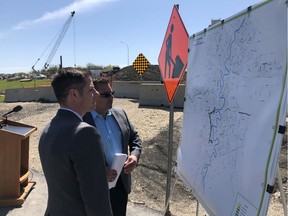 Mayor Brian Bowman (left) and the city's director of public works Jim Berezowsky look over a map of road construction set for 2019 in Winnipeg on Monday.