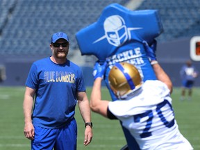 Head coach Mike O'Shea (left) watches as receiver Dylan Schrot works over a tackling dummy during Winnipeg Blue Bombers training camp at IG Field on Wed., May 29, 2019. Kevin King/Winnipeg Sun/Postmedia Network