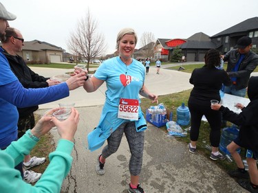 Jaime Mann grabs a water cup on Eastoak Drive during the Winnipeg Run for Women, held at Centre scolaire Leo-Remillard in Winnipeg, on Sun., May 12, 2019. There were over 1,600 people registered to participate, with pledges and donations supporting mental health programs at Mood Disorders Association of Manitoba. Kevin King/Winnipeg Sun/Postmedia Network