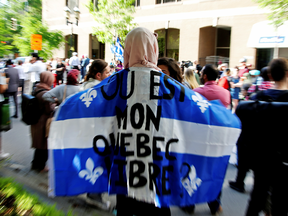 A woman holds a flag with the slogan "Where is my free Quebec" while protesting Quebec's new Bill 21 in Montreal on June 17, 2019.