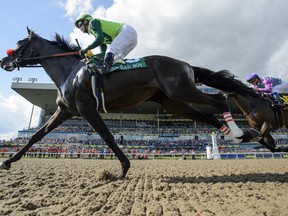 One Bad Boy, ridden by jockey Flavien Prat, wins the 160th running of the Queen’s Plate at Woodbine Racetrack yesterday.  (Andrew Lahodynskyj/The Canadian Press)