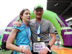 Edmonton's Daryl Lang, who is blind, celebrates the completion of the Full Marathon with her race guide, Ed Gallagher, at the 41st Manitoba Marathon in Winnipeg, on Sunday.