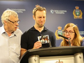 Michael Silicz, flanked by his father Walter and mother Nicole, weeps as he speaks about his brother Justin, who was killed in what police are calling a completely random act of violence on Sunday.