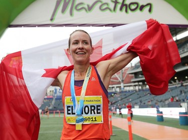 Malindi Elmore, who lives in Kelowna, B.C., is all smiles as she holds out a Canadian flag after winning the Women's Half Marathon National Championships at the Manitoba Marathon in Winnipeg, Man., on Sunday, June 16, 2019.