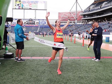 Malindi Elmore, who lives in Kelowna, B.C., raises her arms as she runs through the tape at the finish line to win the Women's Half Marathon National Championships at the Manitoba Marathon in Winnipeg, Man., on Sunday, June 16, 2019.