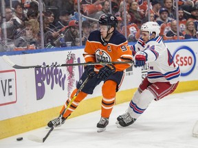 Connor McDavid of the Edmonton Oilers, keeps the puck from Neal Pionk of the New York Rangers at Rogers Place in Edmonton  on March 3, 2018.  Photo by Shaughn Butts / Postmedia