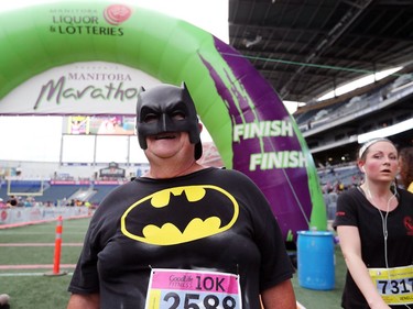 Ray Chartrand, who is dressed like Batman, crosses the finish line in the 10 kilometre run at the 41st annual Manitoba Marathon in Winnipeg, Man. on Sunday, June 16, 2019.