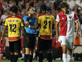 Referee Marie-Soleil Beaudoin gestures to Darnell King of the Fort Lauderdale Strikers as Tom Heinemann of the Ottawa Fury walks away during an NASL match at TD Place in Ottawa on August 9, 2014. (Jana Chytilova / Ottawa Citizen)